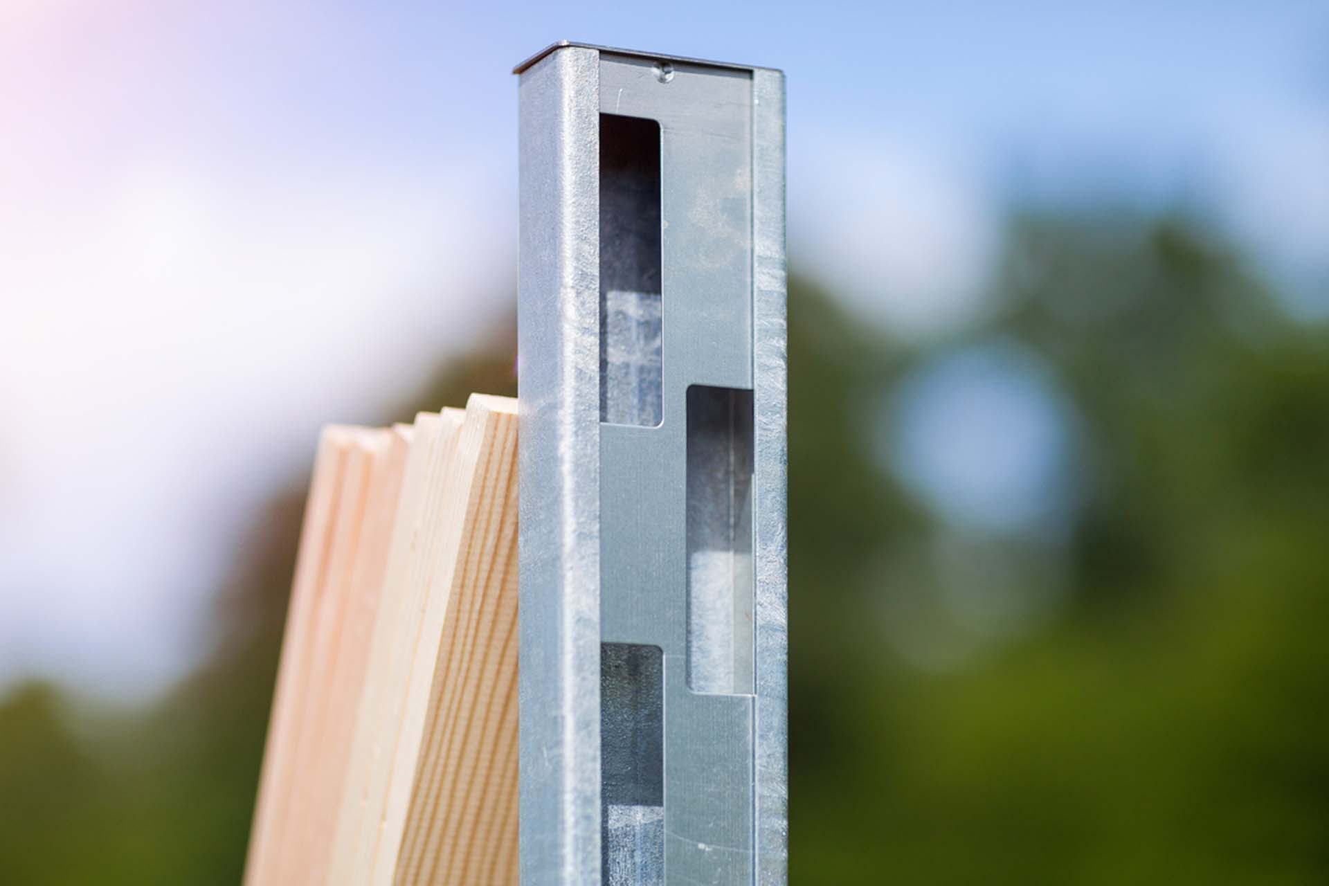 Detailaufnahme eines Metallprofils mit Aussparungen zur schraubfreien Befestigung von Holzbrettern.